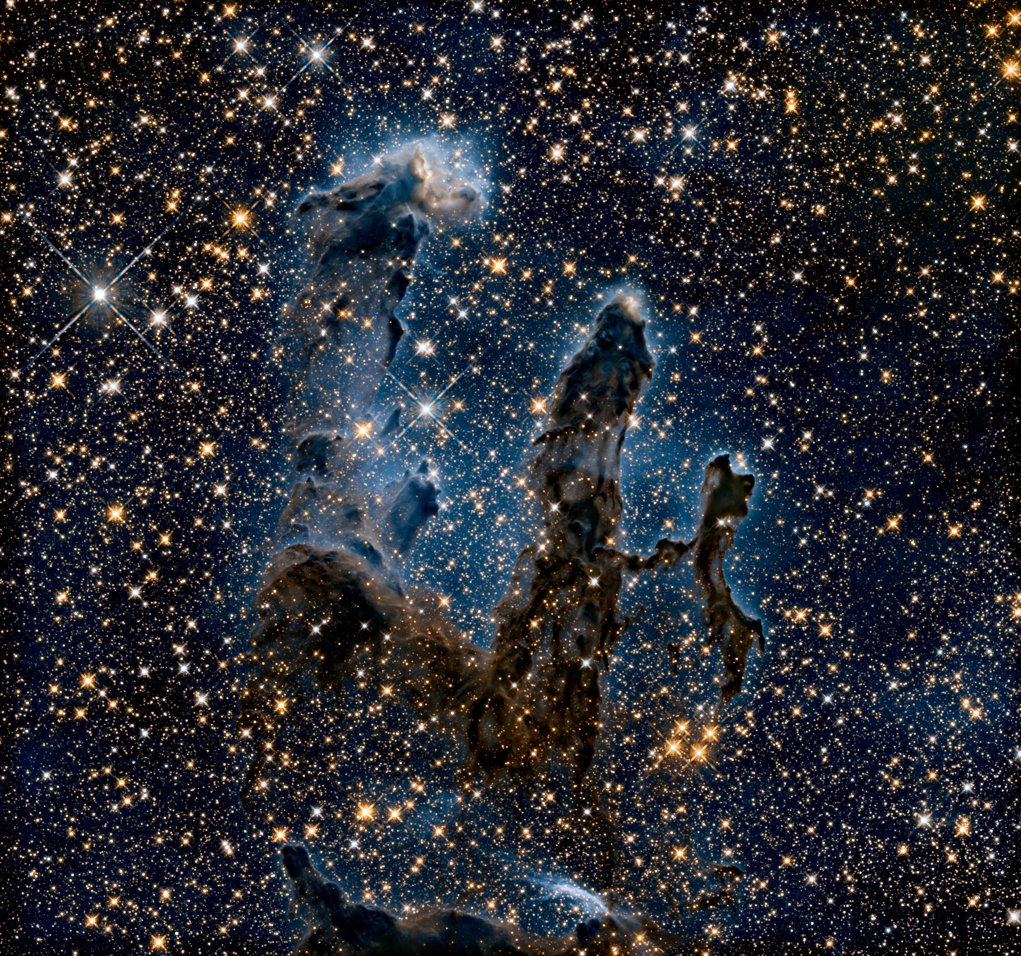 The Pillars of Creation star-forming region imaged against a dense starfield.
